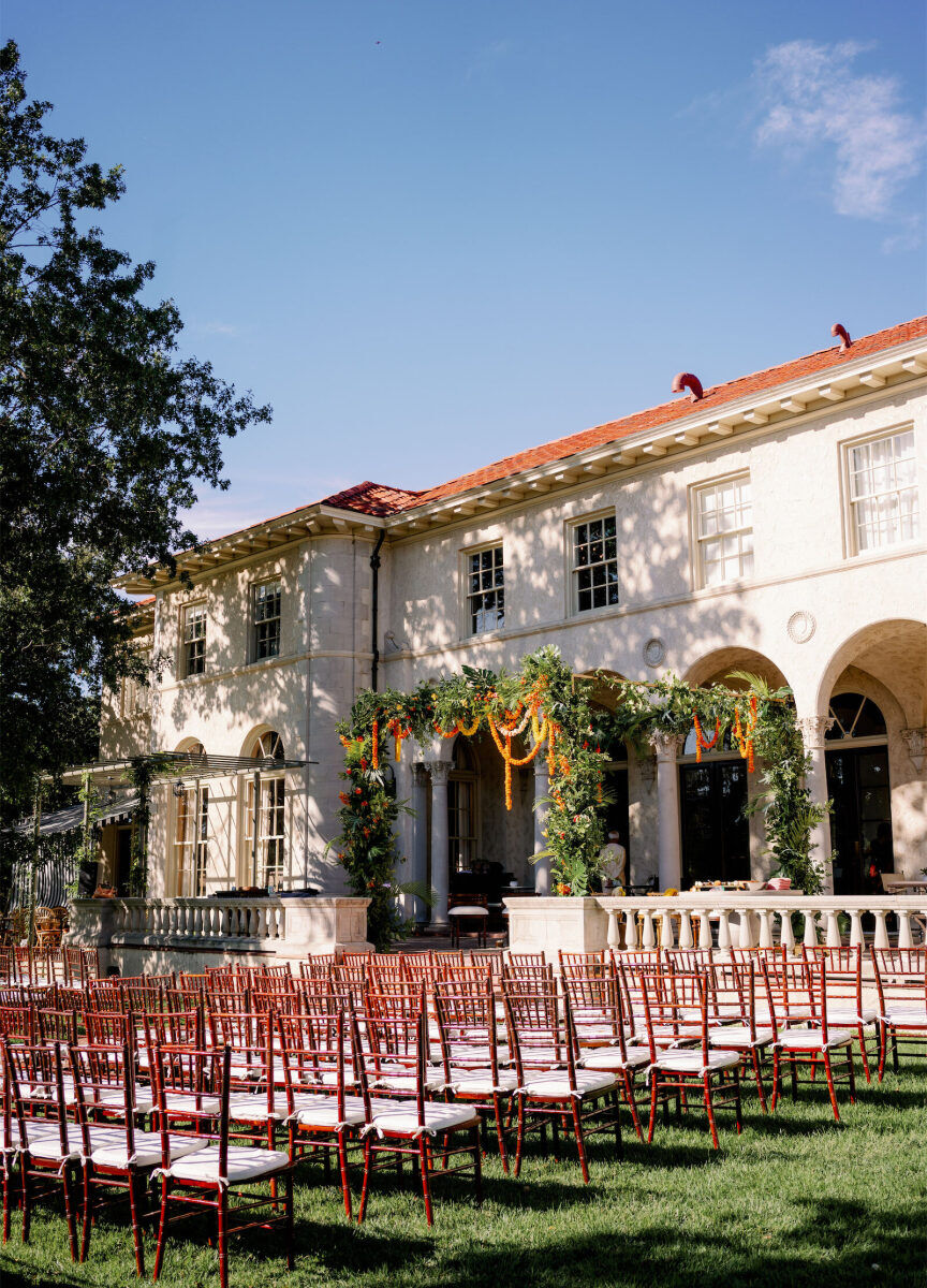 An Indian fusion wedding ceremony anchored by a large, colorful mandap.