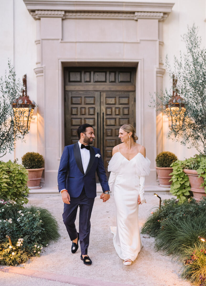 Newlyweds changed into a navy blue suit and off-the-shoulder dress for their Indian fusion wedding reception.